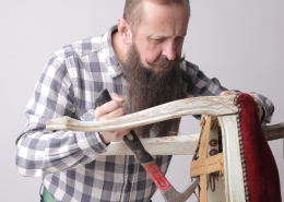 vertical-shot-man-with-long-beard-mustache-fixing-broken-chair_181624-23276